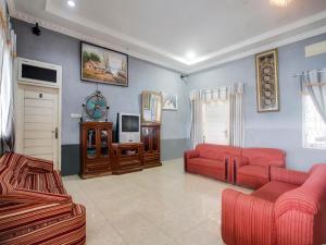 班达楠榜OYO 91005 Cottage Putra Mutun Beach的客厅配有2张红色沙发和电视