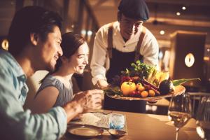石垣岛全日空石垣岛洲际度假酒店的一群坐在餐桌上的人,拿着一盘食物