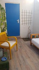 埃拉特Carmona's Patio的一间设有蓝色门和黄色椅子的房间