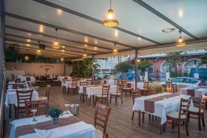 蒂锡利维ALADDIN TSILLIVi的餐厅配有白色的桌椅和灯光