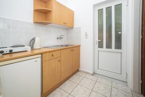 蒂锡利维ALADDIN TSILLIVi的厨房配有木制橱柜、水槽和门