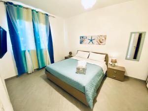 托雷斯港Luisa Home的一间卧室配有一张带蓝色毯子和窗帘的床