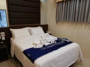 CalapanNutriTECH Hotels & Events的一间酒店客房,配有一张带毛巾的床