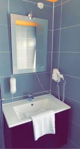 贝尔恩卡斯特尔-库斯Hotel-Restaurant Kastel的一间带镜子和电话的盥洗盆的浴室