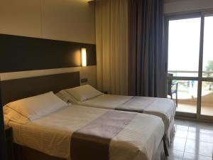 诺哈拉斯登纳斯酒店的配有窗户的酒店客房内的两张床