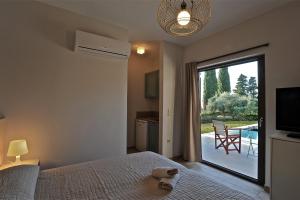 米尼亚艾拉雅别墅酒店的一间卧室设有一张床和一个带庭院的滑动玻璃门。