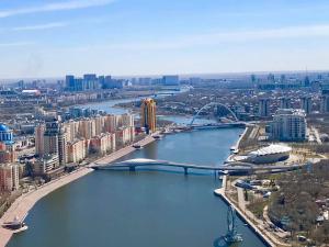 阿斯塔纳Апартаменты на набережной с панорамным видом на 39 этаже的享有河流和桥梁城市的空中景色