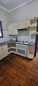 彼得马里茨堡Fairfield Guest House的铺有木地板,设有带炉灶的厨房。
