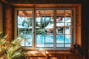 拉姆绍达赫斯坦林德霍夫酒店的窗户享有带遮阳伞的游泳池景致