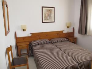 罗列特海岸桑蒂公寓的一间卧室配有一张带条纹床罩的床和一张书桌