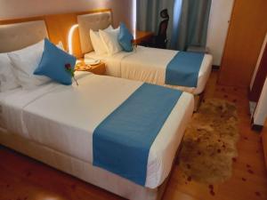 亚的斯亚贝巴Z Addis Hotel的酒店客房带两张带蓝白床单的床。