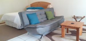 姆巴巴内Liz' Cottage的客厅配有沙发和1张床