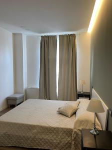 维罗纳CALLA, CALLUNA & GARDENIA APARTMENTS的一间卧室设有一张大床和一个窗户。