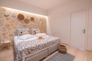 卡沃斯Ekati Mare Boutique Resort的一间卧室设有一张床和石墙