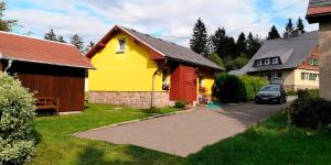 克林根塔尔Ferienhaus Brigitte的一辆黄色和红色的房子,车道上停有一辆汽车