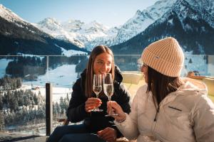米特尔贝格马蒂斯旅馆的两个女人在山前拿着酒杯