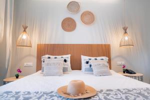卡沃斯Ekati Mare Boutique Resort的一间卧室,配有一张床,上面有帽子