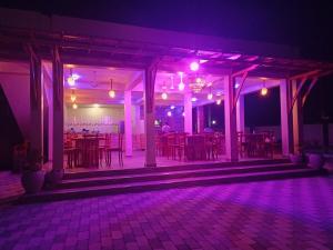 达累斯萨拉姆Chibuba Airport Accommodation的配有桌椅和紫色灯的房间