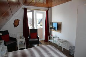 滕宁古德龙旅馆的一间卧室设有一张床、一台电视和一个窗口。