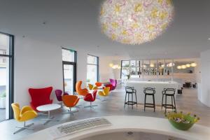卢加诺卢加诺城市酒店的大堂设有色彩缤纷的椅子和大吊灯