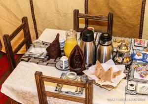 扎古拉Sahara Relax Camps的一张桌子,上面有白色的桌布,上面有食物