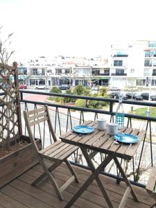 鲁瓦扬Appartement Royan, 200 m de la PLAGE的观景阳台的木桌和椅子