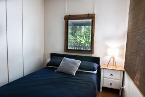 PomonaNoosa Rural Retreat的一间设有蓝色床和窗户的小卧室