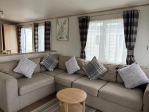 Swayforest beach bashley park的客厅配有沙发和桌子