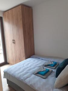 迪瓦伊巴雷Pahulja的一间卧室配有一张带蓝色床单和木制橱柜的床。