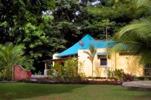曼萨尼约Private Villa on 2-Acres of Jungle Garden & Pool的蓝色屋顶的黄色小房子