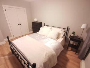 伦敦Modern 1 bedroom apartment in Wortley Village的卧室配有一张带白色床单和枕头的大床。