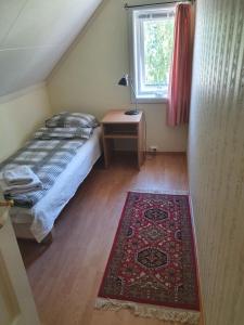史特林Sjarmerende feriehus i Olden rett ved fjorden的一间卧室配有一张床、一张桌子和一张地毯。
