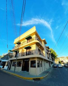 南圣胡安拉艾斯塔恩酒店的街道拐角处的黄色建筑