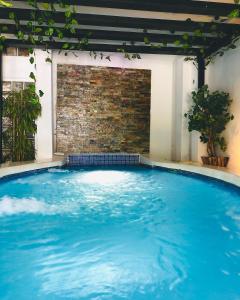 南圣胡安拉艾斯塔恩酒店的一座大型蓝色游泳池,设有砖墙