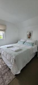 特木科Prairie's House的白色卧室配有一张大床和毛巾
