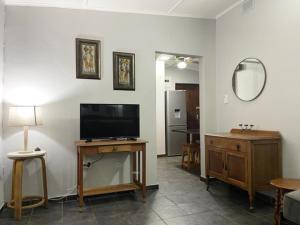 姆通济尼Umlalazi Cottage的客厅配有平面电视和桌子。