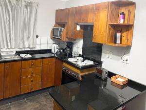 姆通济尼Umlalazi Cottage的厨房配有木制橱柜和炉灶烤箱。