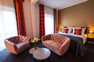 日内瓦大使酒店的酒店客房,配有一张床和两把椅子