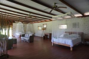Teahupoo瓦尼拉旅舍的一间卧室配有两张床和吊扇