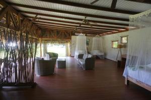 Teahupoo瓦尼拉旅舍的一间带椅子、一张床和一张桌子的房间