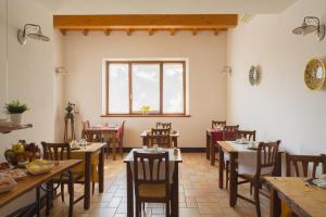 沃尔塔曼托瓦纳阿达莫葡萄园农家乐的一间带桌椅的用餐室和窗户。