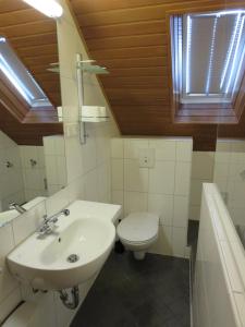 盖尔森基兴Ruhrzimmer的白色的浴室设有水槽和卫生间。