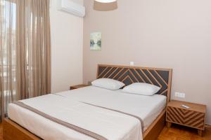 塞萨洛尼基Αριστοτέλους Comfy Apt.的一间卧室配有一张带白色床单的床和一扇窗户。