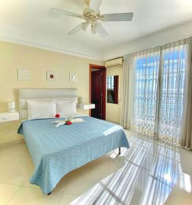 圣多明各Hotel Shakey的一间卧室配有一张蓝色的床和吊扇