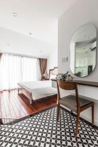 胡志明市Ngan Ha 2 Apartments的一间卧室配有一张床、镜子和椅子
