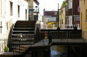 法尔肯堡Onder de Linde B&B的一座河上的桥,有楼梯和建筑