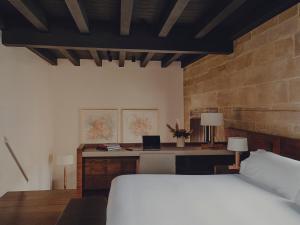 布里奥内斯Santa María Briones的一间卧室配有一张床和一张带笔记本电脑的书桌