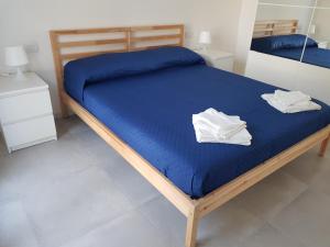 托里格兰德Casa Tonia的床上铺有蓝色床单和白色毛巾