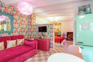 科尔库维翁La Suite Años 50 La casa Barbie Bañera chimenea的一间带粉色沙发的客厅和一间卧室