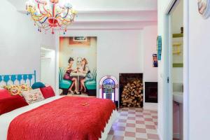 科尔库维翁La Suite Años 50 La casa Barbie Bañera chimenea的一间卧室配有一张床和一个吊灯